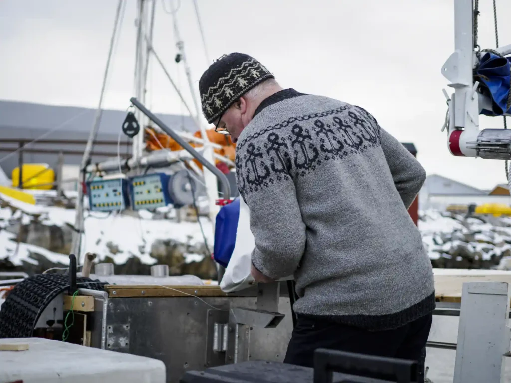 Fischer arbeitet am Boot im Winterhafen Nordnorwegen